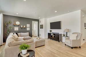Living area featuring light wood-style flooring, baseboards, and recessed lighting