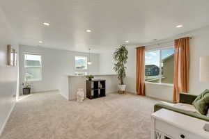 Living room featuring recessed lighting, baseboards, and light carpet