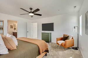 Bedroom featuring visible vents, a ceiling fan, baseboards, light colored carpet, and ensuite bathroom
