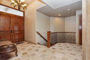 Foyer featuring baseboards, an inviting chandelier, recessed lighting, and crown molding