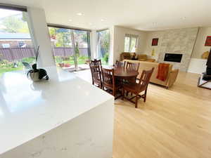 Dining room with a fireplace, recessed lighting, and light wood-style floors