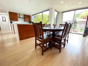 Dining space with a wall of windows, light wood-style floors, and recessed lighting