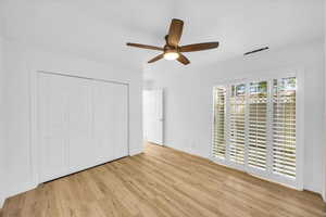 Unfurnished bedroom with baseboards, a ceiling fan, wood finished floors, and a closet