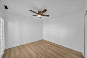 Spare room with baseboards, a ceiling fan, and wood finished floors