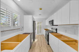 Kitchen featuring white cabinets, stainless steel appliances, and plenty of natural light