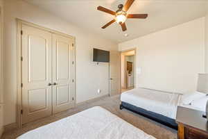Bedroom with carpet, a closet, a ceiling fan, and baseboards