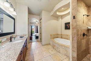 Bathroom with a garden tub, vanity, ensuite bathroom, and tiled shower