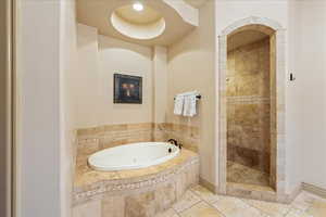 Bathroom featuring a tile shower and a bath