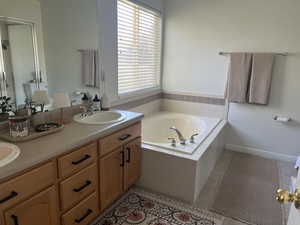 Master bathroom with a shower stall, tile patterned floors, a bath, and a sink