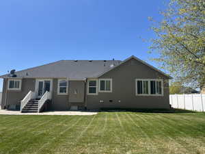 Back of house featuring fence, a patio area, and a yard