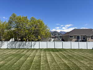 View of yard featuring fence and a mountain view