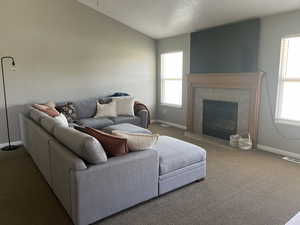 Living room with vaulted ceiling, a fireplace.
