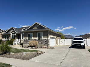 View of front of property featuring a gate, fence, stucco siding, an attached garage, and concrete driveway