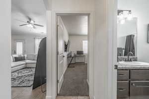 Bathroom featuring baseboards, tile patterned floors, vanity, and ceiling fan