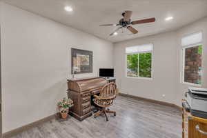 Office area featuring light wood finished floors, a ceiling fan, baseboards, and recessed lighting