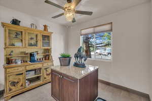 Home office featuring a ceiling fan, baseboards, and light tile patterned floors