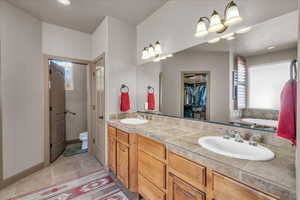 Bathroom with a garden tub, toilet, a sink, and double vanity