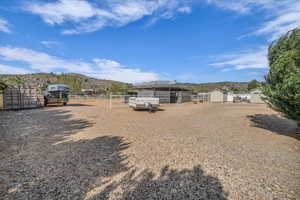 View of yard with an outdoor structure, fence, and a mountain view