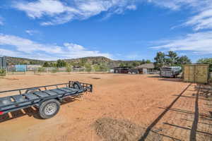 View of yard featuring fence, a rural view, and a mountain view