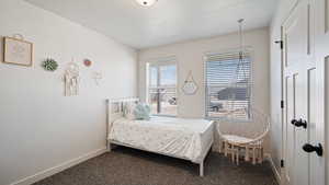 Bedroom with carpet, a textured ceiling, and baseboards