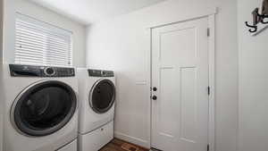 Clothes washing area featuring washing machine and dryer, visible vents, dark wood-style floors, and laundry area