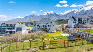 Rear view of house with a fenced backyard, stairs, and a mountain view