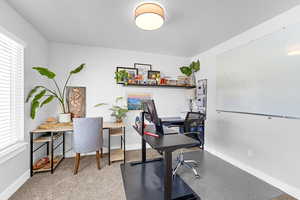 Home office with a textured ceiling, a wealth of natural light, and baseboards