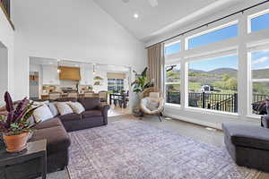 Living room with recessed lighting, visible vents, a ceiling fan, a mountain view, and high vaulted ceiling