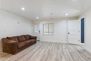 Living area featuring baseboards, visible vents, light wood finished floors, and recessed lighting