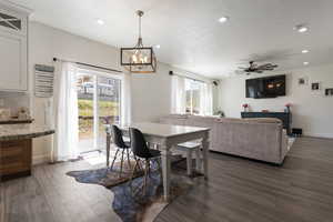 Dining room with recessed lighting, wood finished floors, a textured ceiling, and ceiling fan with notable chandelier