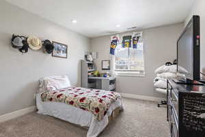 Bedroom featuring baseboards, visible vents, a textured ceiling, and carpet flooring