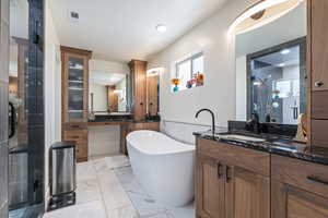 Full bathroom with a soaking tub, vanity, marble finish floor, and a stall shower