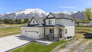 View of front of property featuring an attached garage, covered porch, a mountain view, and concrete driveway
