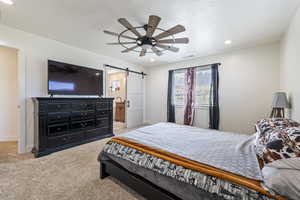 Bedroom with light carpet, a barn door, baseboards, visible vents, and recessed lighting