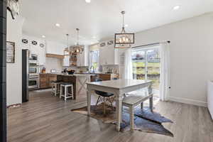 Dining area with light wood-type flooring, baseboards, recessed lighting, and a chandelier