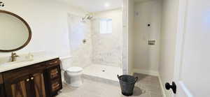 Full bath with vanity, tile patterned flooring, toilet, and tiled shower. Hookups for stackable washer and dryer.