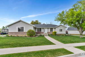Ranch-style house with a front lawn and brick siding
