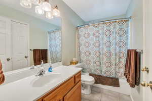 Full bathroom featuring vanity, toilet, tile patterned flooring, and shower / tub combo with curtain