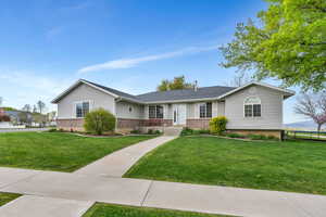 Single story home featuring a front yard, fence, and brick siding
