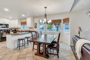 Dining room featuring light tile patterned flooring, a chandelier, recessed lighting, and baseboards