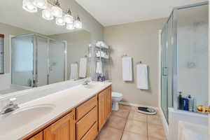 Full bathroom with tile patterned flooring, a sink, a shower stall, and double vanity