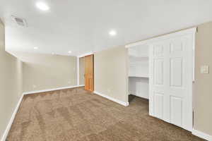 Finished below grade area with baseboards, carpet flooring, visible vents, and recessed lighting