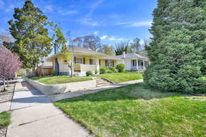Ranch-style house with concrete driveway, a front yard, and fence