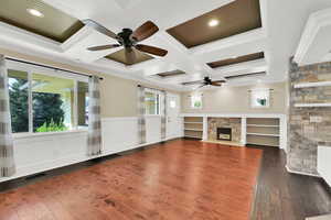 Unfurnished living room with visible vents, a ceiling fan, a stone fireplace, and ornamental molding