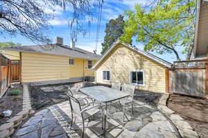 Back of house with cooling unit, a fenced backyard, a patio, and outdoor dining area