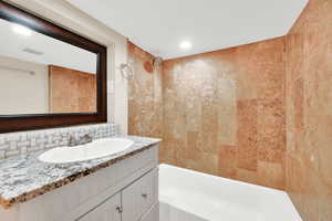 Bathroom featuring decorative backsplash, vanity, tub / shower combination, visible vents, and recessed lighting