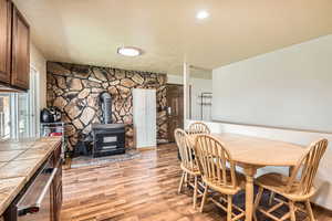 Dining space featuring light wood-type flooring and a wood stove