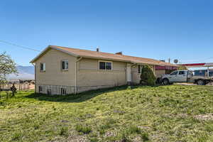 Ranch-style home with fence, brick siding, a front yard, and a mountain view