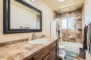 Bathroom featuring toilet, vanity, and shower / bath combo with shower curtain
