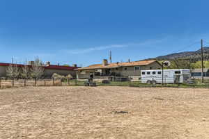 Rear view of property featuring an enclosed area, fence, and a mountain view